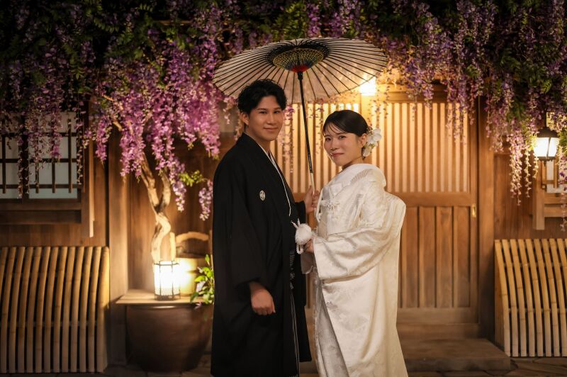 藤の花が咲き誇る和装の傘差しショット