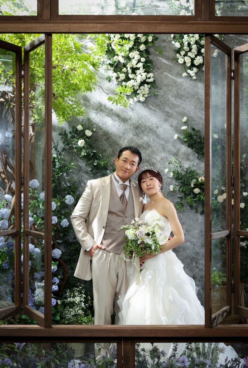 緑と白の花々に囲まれた洋装での並び姿
