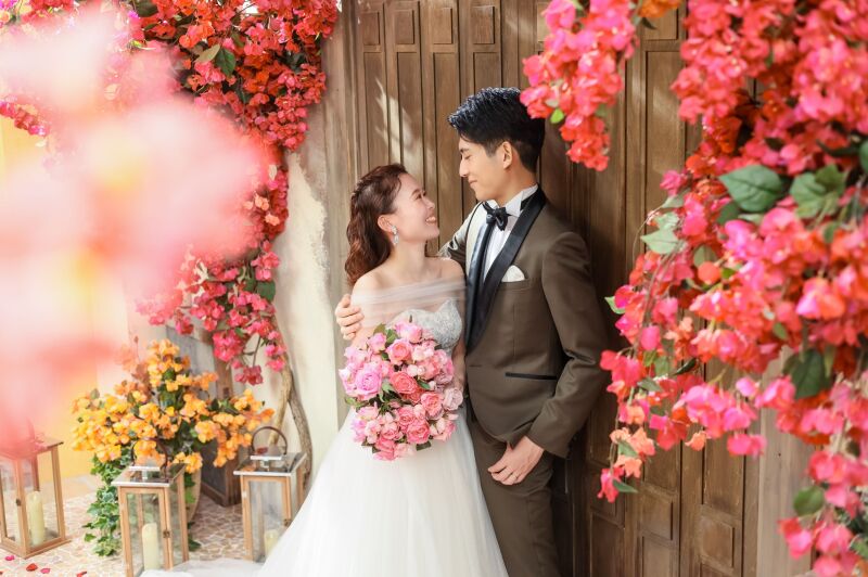 色鮮やかなお花の前で向かい合うお二人の微笑み