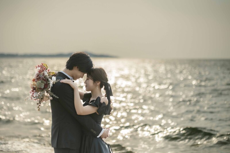 夕陽に照らされキラキラと輝く海をバックに**