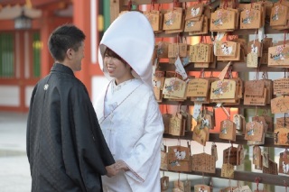 絵馬を背景に白無垢姿