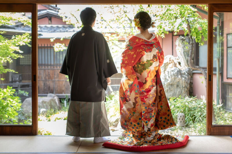 色艶やかな色打掛と庭園の緑が映えるワンシーン