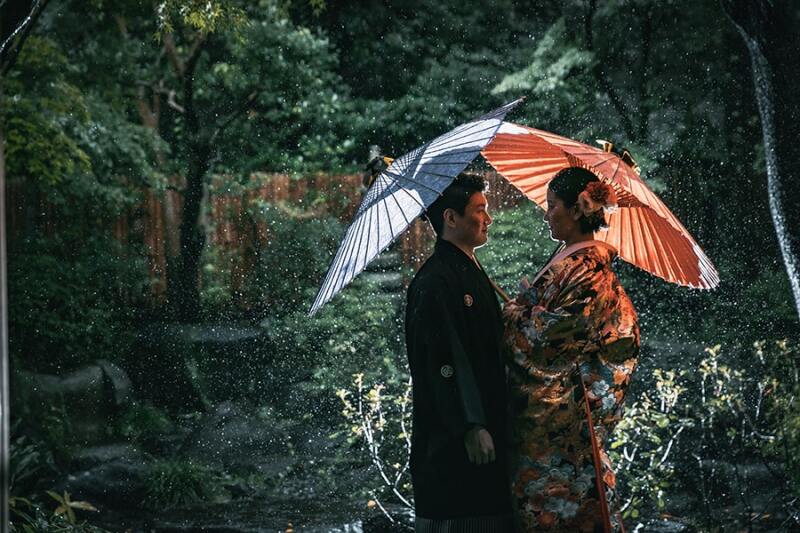 雨のなかで番傘を使って