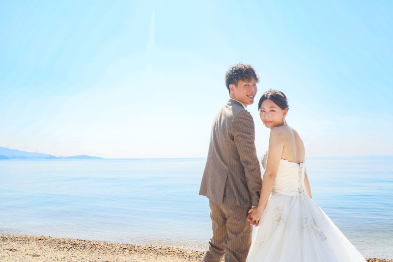 煌めく海をバックに微笑む2人