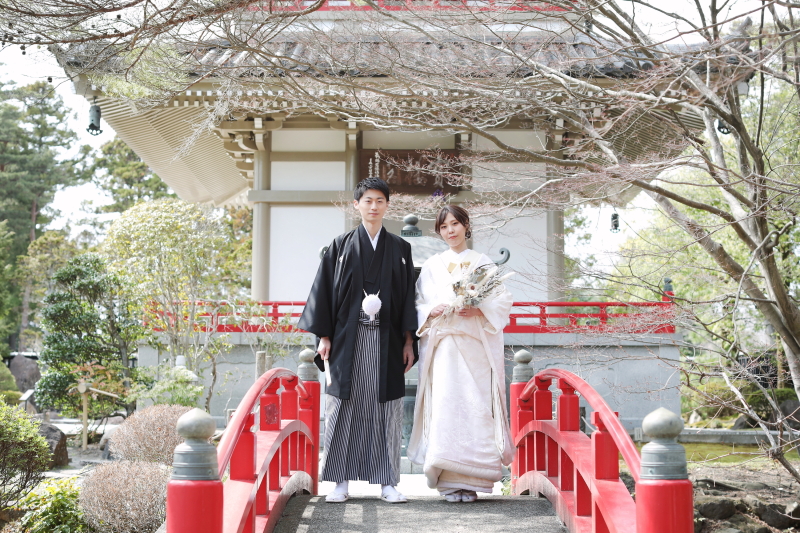 朱色の橋の上に立つ