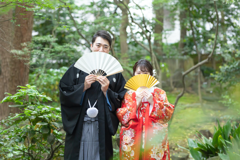 扇子で口元を隠して...