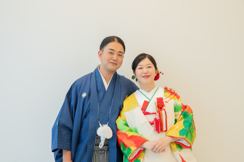 白壁をバックにして、ご新郎様と肩組みショットを!