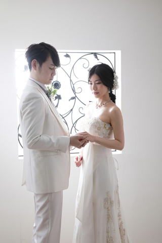 光の差し込む窓の前で指輪交換しているかのように