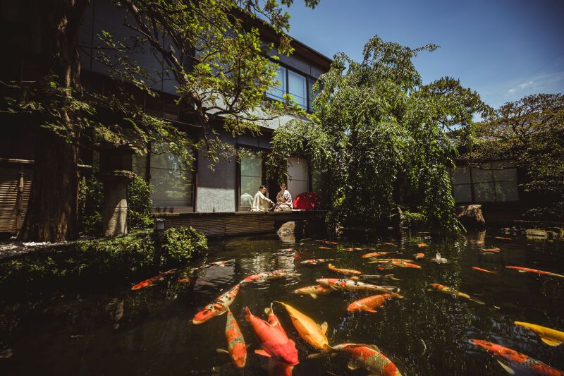 池に面した縁側に、静かに並んで座るふたり。華やかすぎず、でも確かに特別なこの空気感を残したくて、少し距離を置いた構図で池越しにシャッターを切りました。