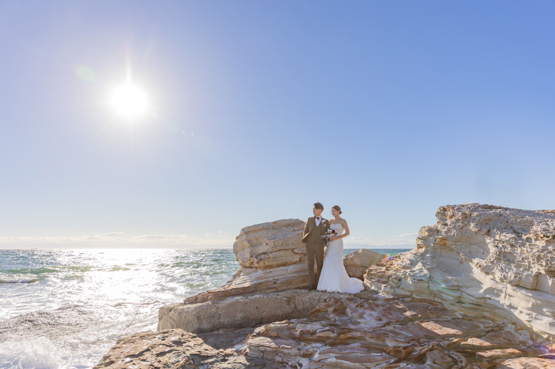 光あふれる岩場に立つふたりの誓いの瞬間