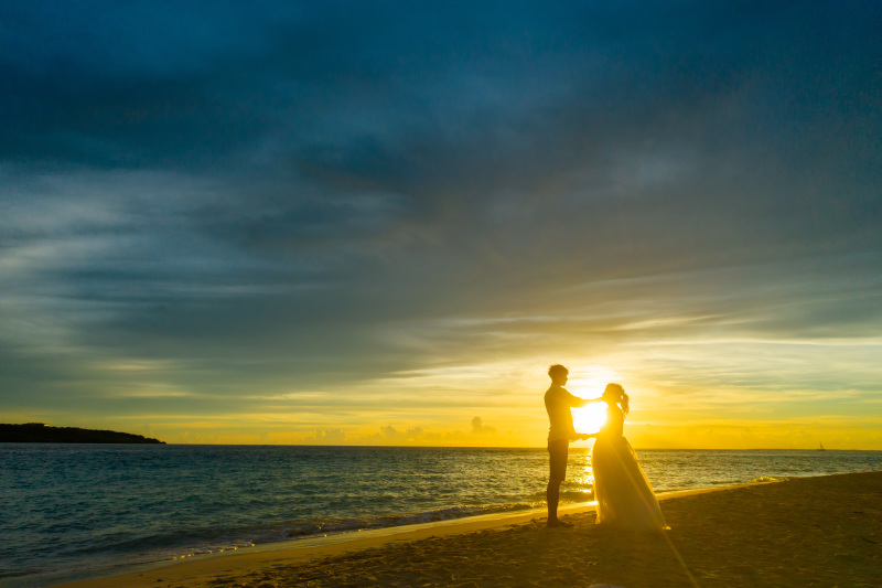 水平線に沈む夕日に染まるお二人