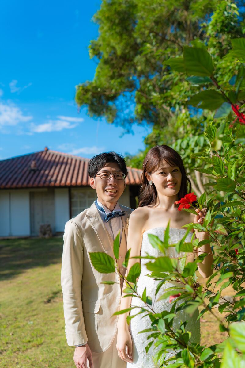 緑あふれるガーデンで、赤いハイビスカスと共に