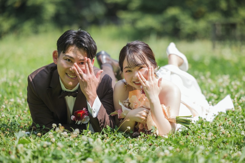 芝生に寝転んで見せるリングポーズ