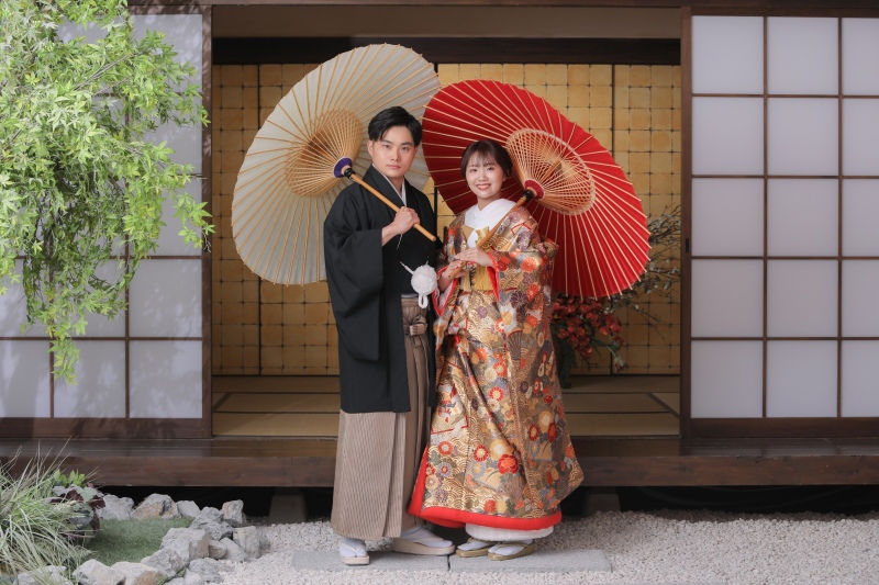 柔らかな光が差し込む和の空間で、和傘を手に寄り添うおふたり。新婦様の優しい笑顔と新郎様の凛々しい表情のコントラストが素敵です。上品でありながら、おふたりの温かい空気感が伝わるカットに仕上げました。