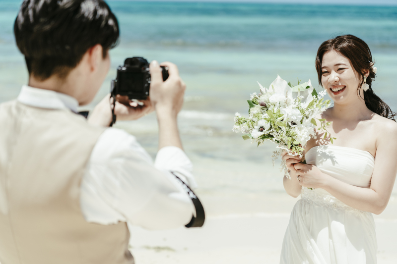 カメラマンの新郎様越しの新婦様