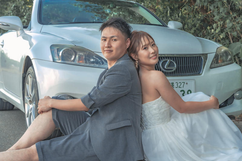 結びには 背中を合わせながら白い素敵な車と共に