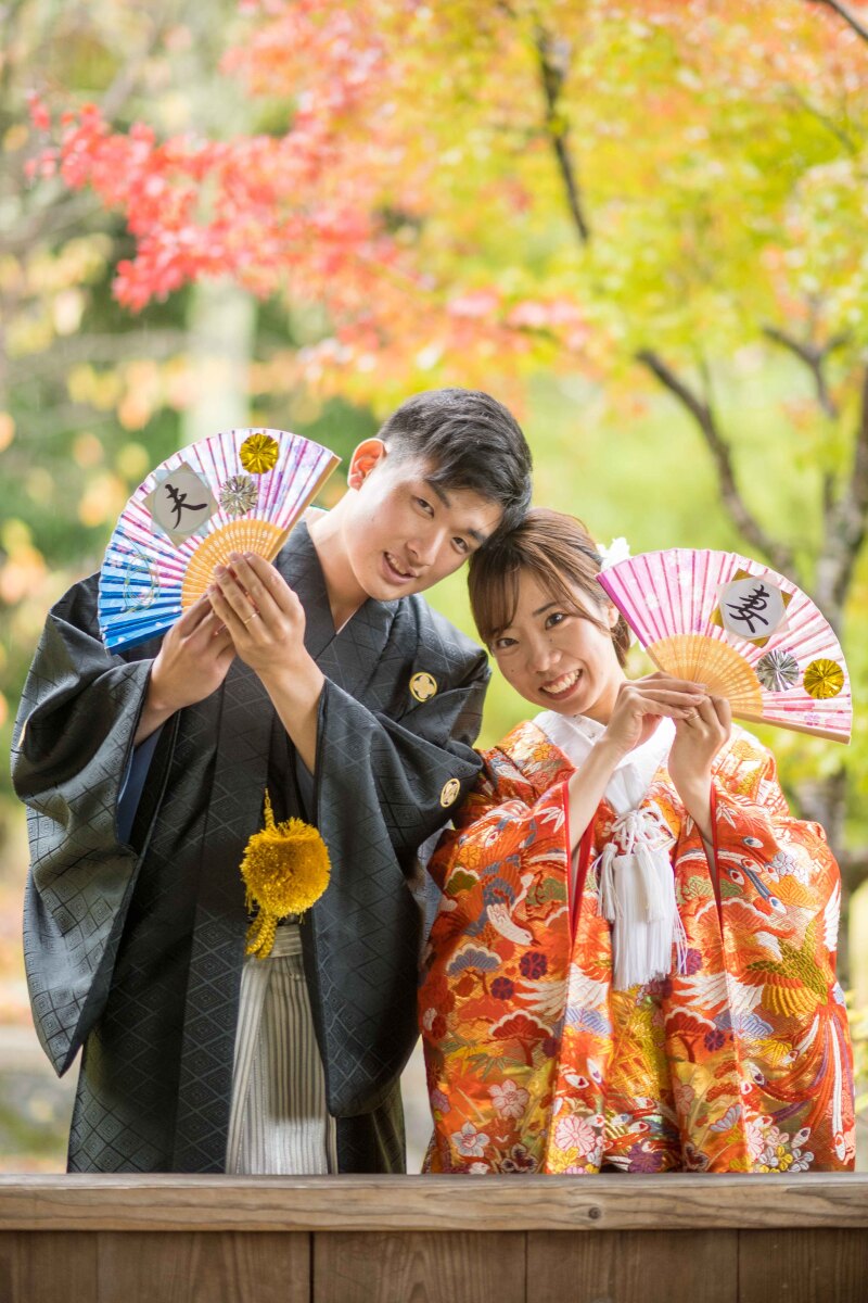 夫、妻の扇子を持って