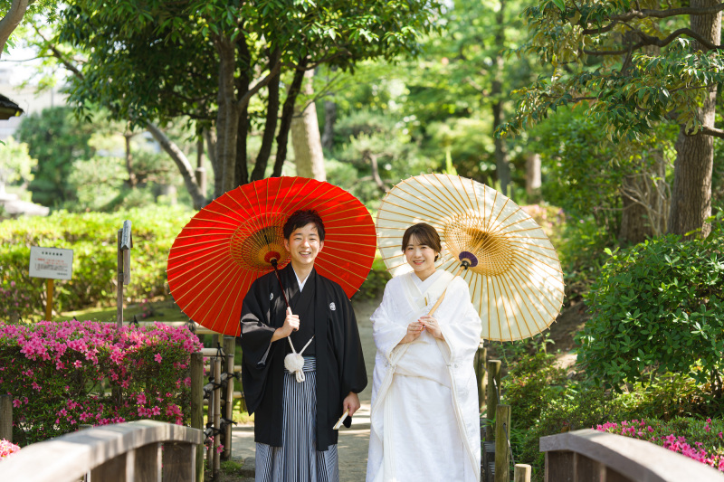 5月の鮮やかな新緑の庭園で映える、紅白の番傘