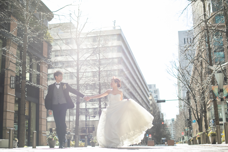 手を取り、明るい日差しの中を歩くお二人