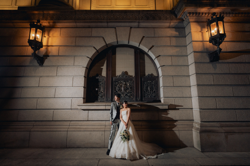 石造りの外壁とアイアンの街灯、アーチ型の窓の前で