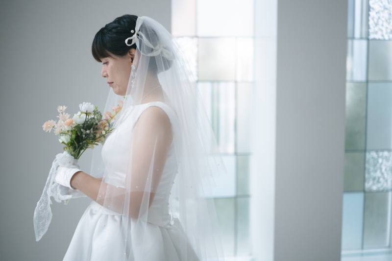 純白のドレスに包まれた花嫁が、そっと横を向く
