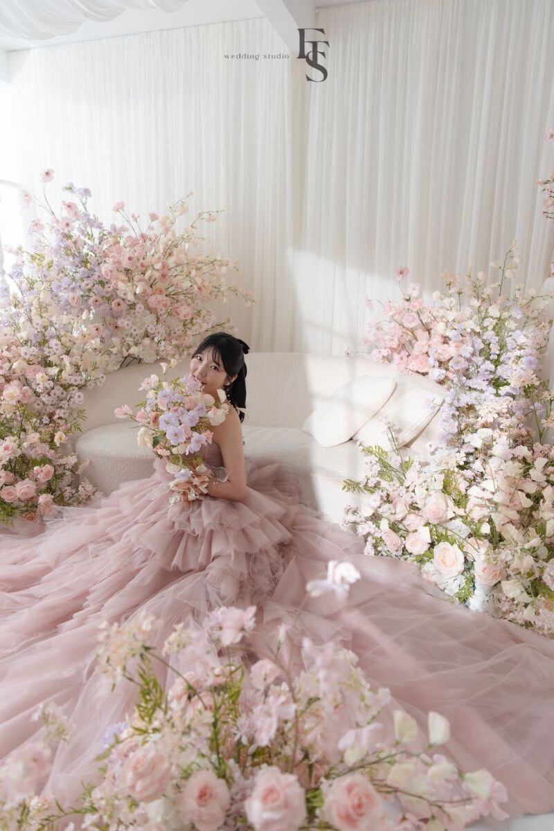 淡いピンクと白の花々に囲まれた、幻想的で可憐な一枚です。ふんわりとしたドレスと柔らかな光がご新婦様の美しさを引き立て、まるで物語のワンシーンのような心ときめく特別な瞬間を美しく切り取りました。