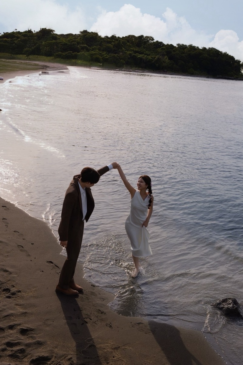 岩場の隙間から望む海と、きらめく水面に浮かぶおふたりの姿。自然がつくる光と影を生かし、まるで映画のワンシーンのように切り取ります。壮大な景色の中にもふたりの存在が美しく際立つ、印象深い一枚です。