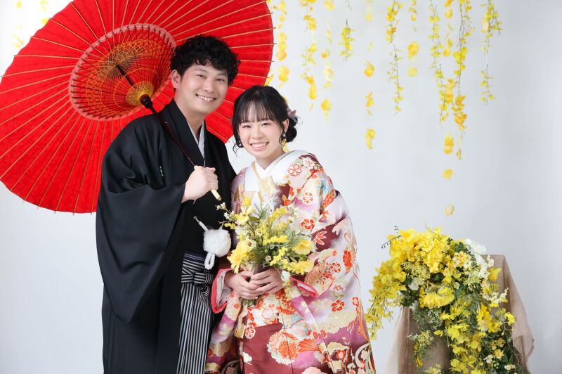 赤い和傘と黄色の花に包まれて