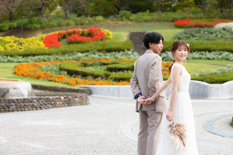 満開の花壇の前で