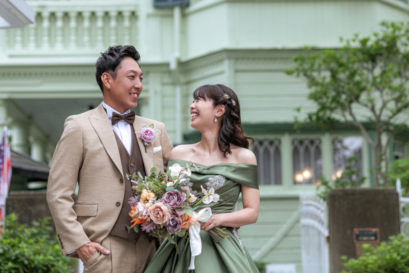 パステルカラーのお洒落な建物をバックに素敵な笑顔