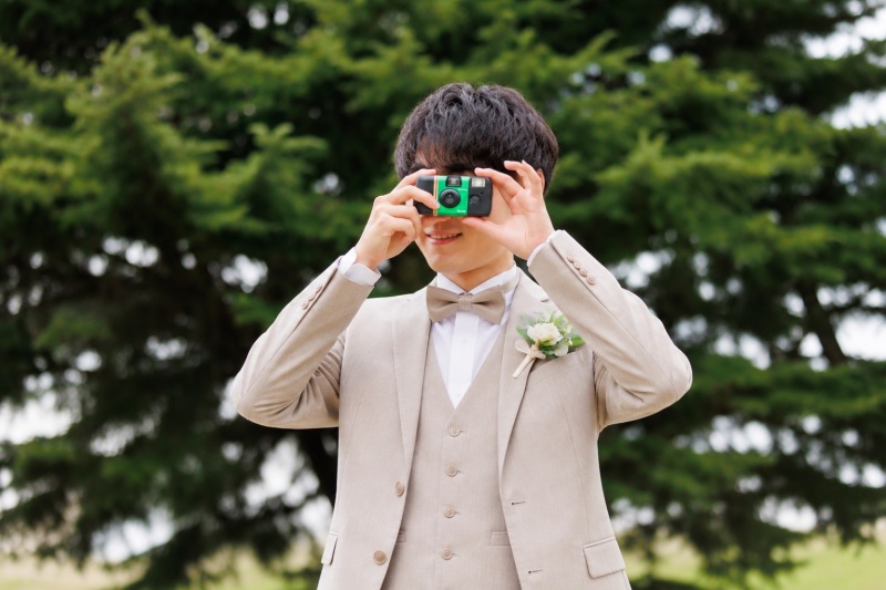 新婦様の姿をフィルムカメラに残す新郎様のショット