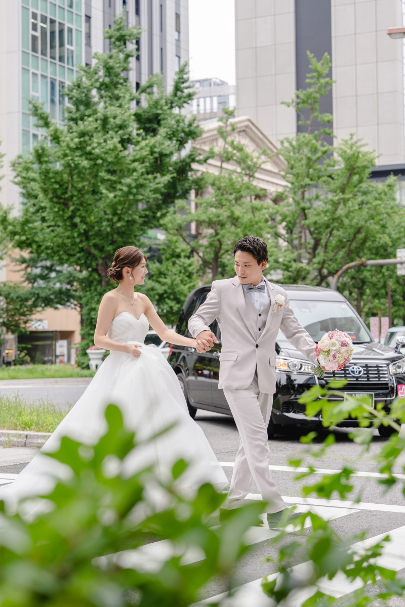 御堂筋の街を歩きながら、ふと交わした視線。手を取り合い、横断歩道を歩くその何気ない瞬間に、作り込まない自然な表情が、そのまま写真になりました。街の喧騒の中でも、おふたりだけの時間が流れていました。