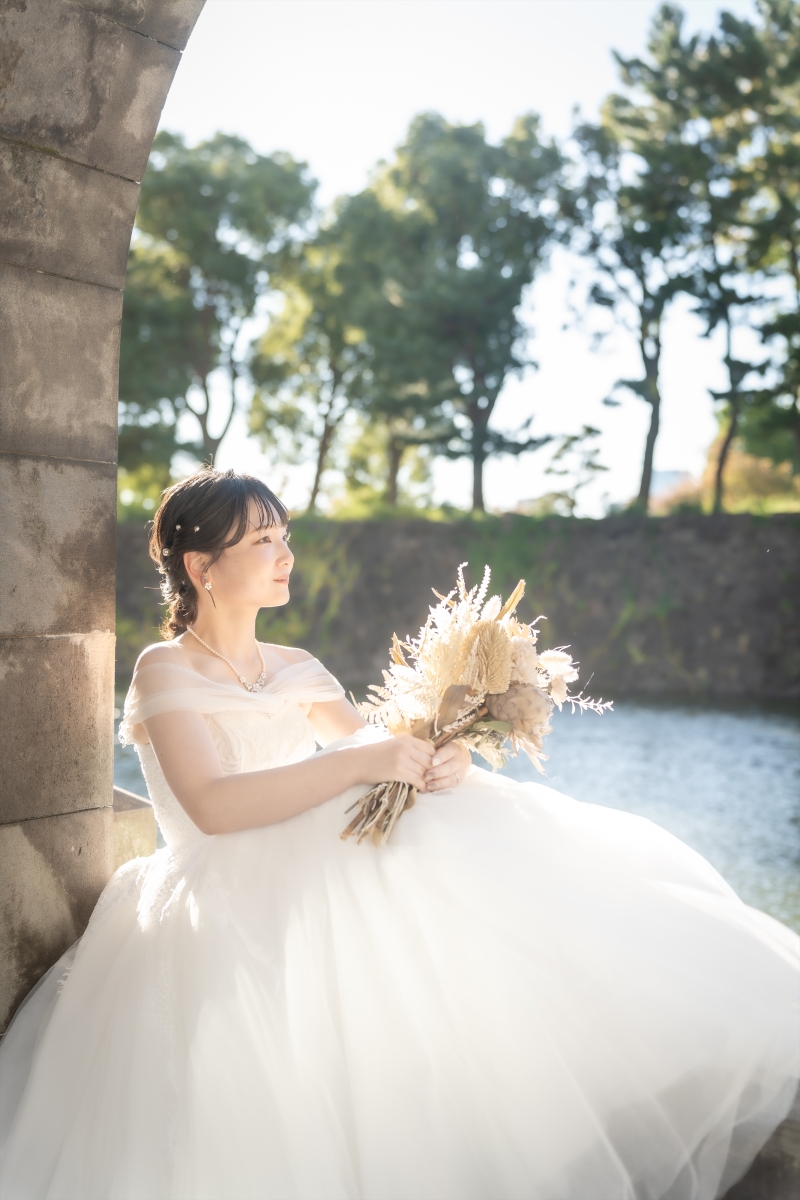 石柱にもたれて横を向いた新婦様の静かな表情