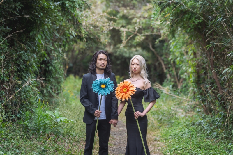 緑のトンネル道で造花を持つ2ショット