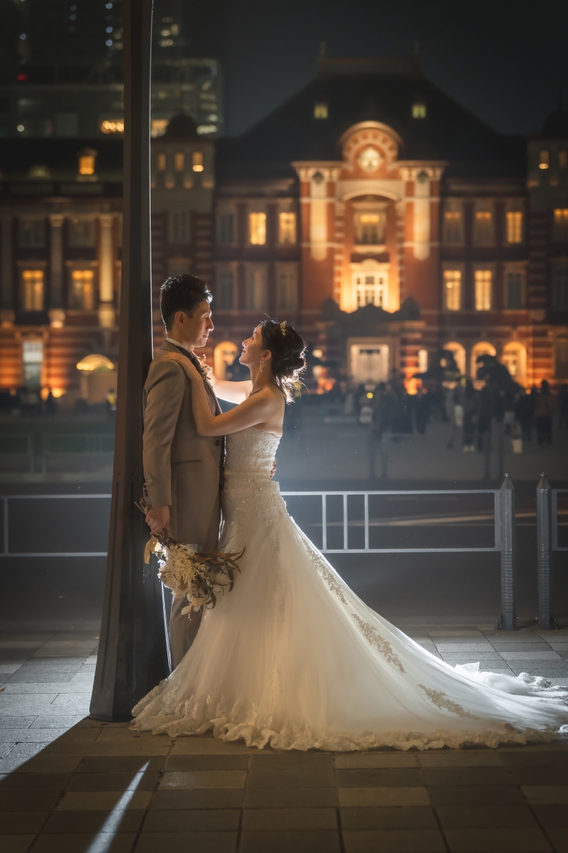 夜の駅舎を背に見上げる二人