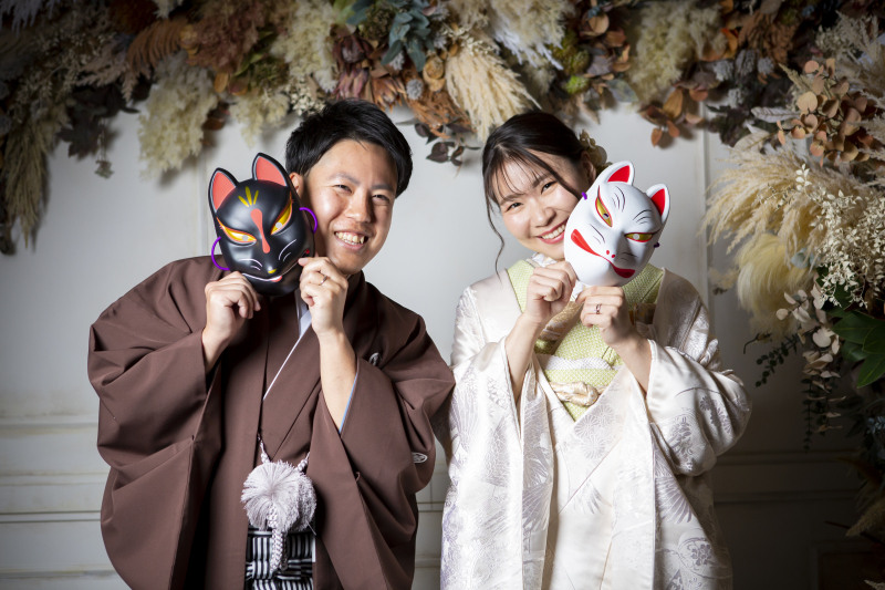 お面から顔を覗かせて