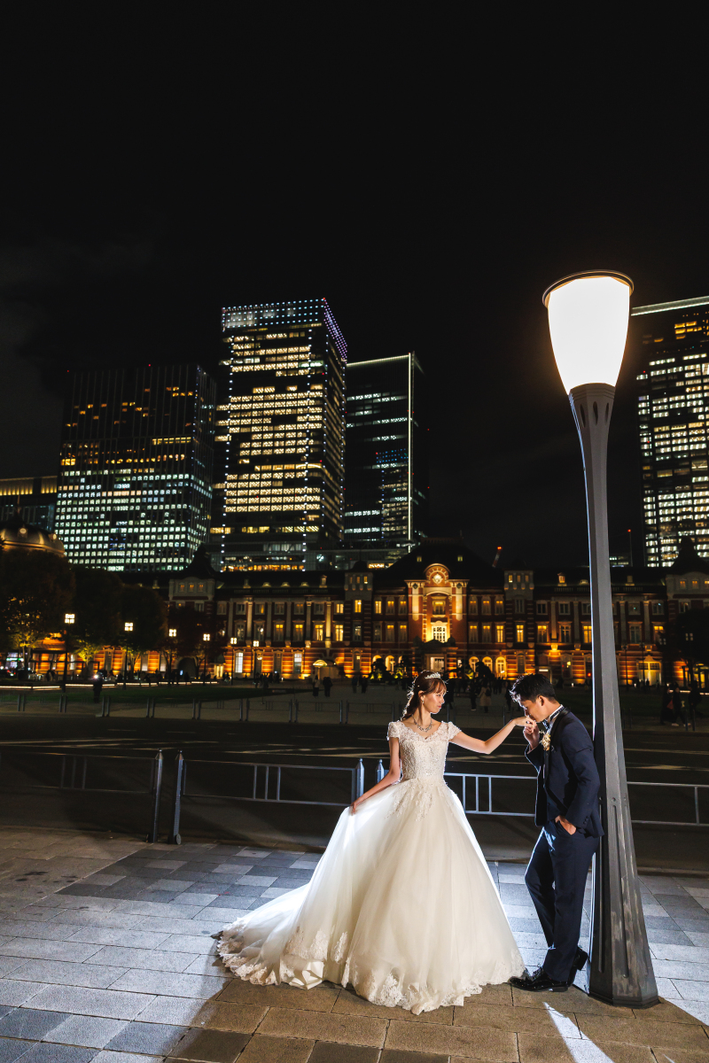 街灯の下で手を取られ佇む花嫁