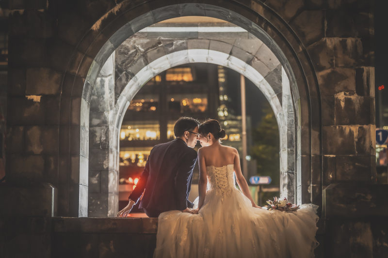 夜景を見つめながら寄り添うふたりの後ろ姿