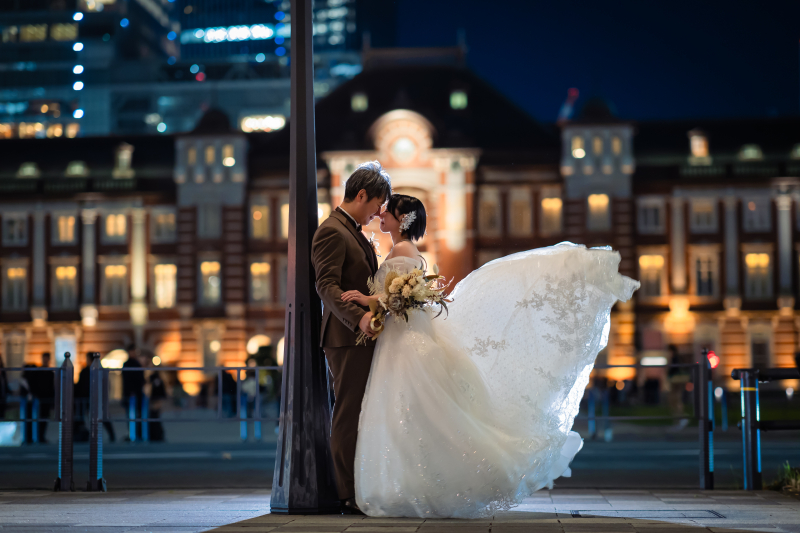 ドレスをなびかせ東京駅前で寄り添う