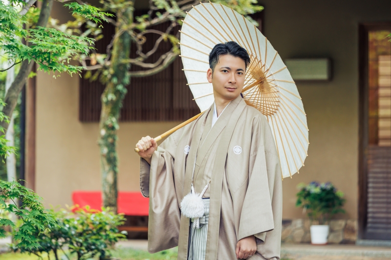 白い番傘を差して佇む紋付袴の落ち着き