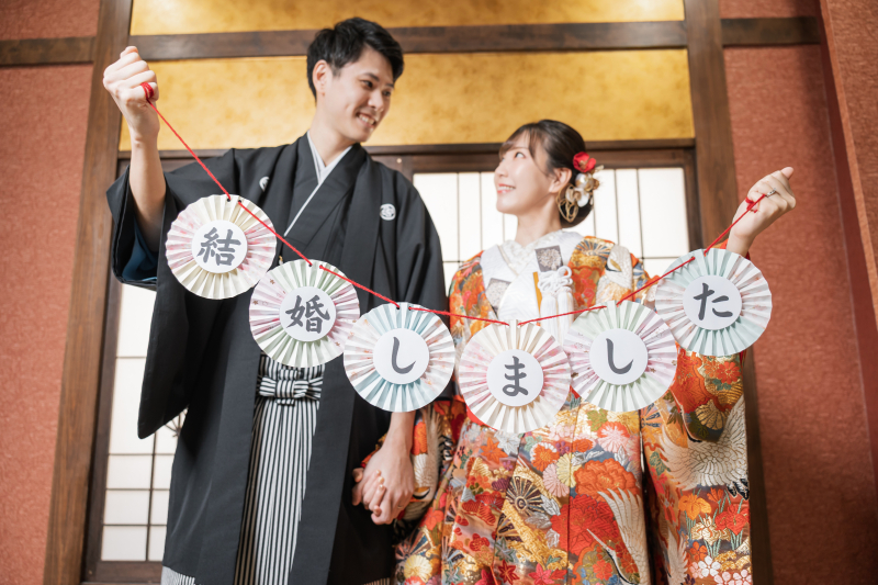 「結婚しました」のガーランドを二人で掲げ合う