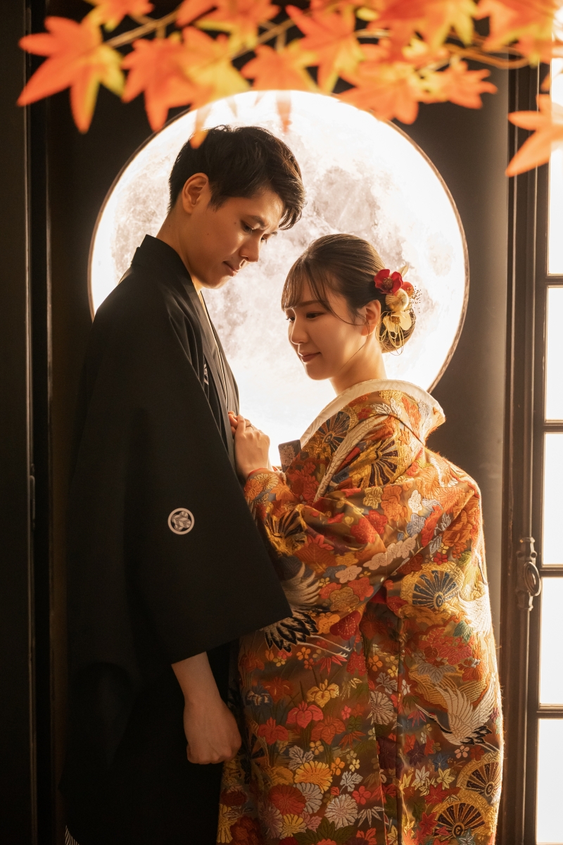 丸窓の前で腕にそっと触れ見上げる色打掛