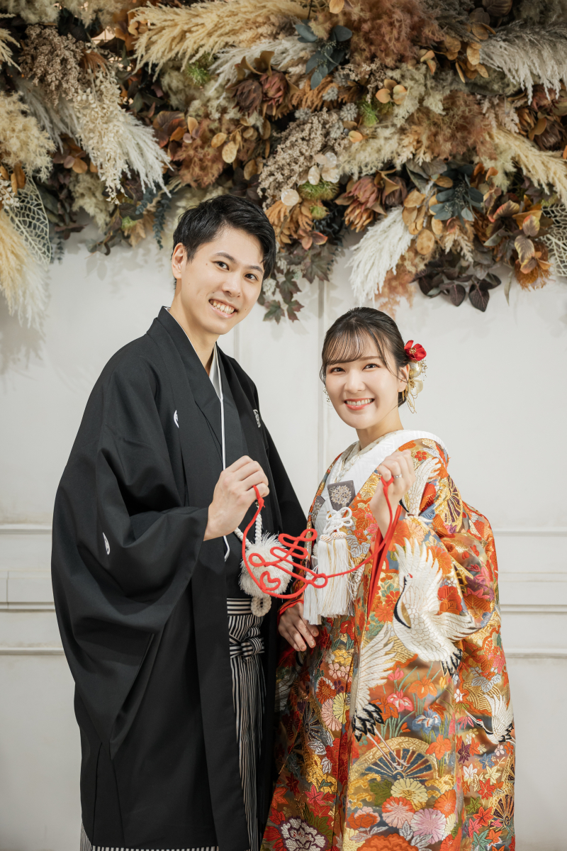 赤い組紐を手に笑顔で並ぶ晴れやかさ