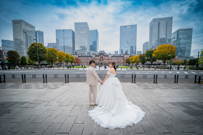 東京駅と高層ビルを背に手を繋ぐドレス