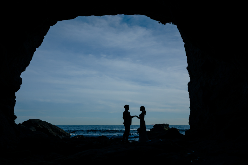 洞窟越しの海と向き合うシルエット