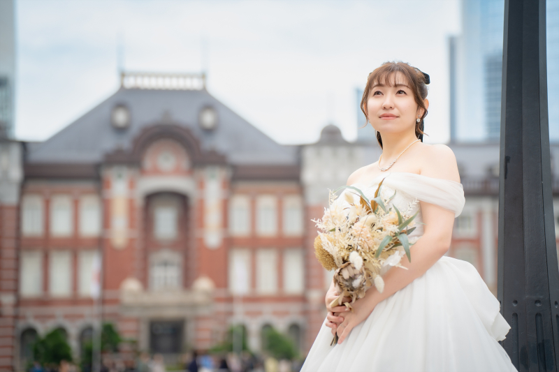東京駅を背景にブーケを持つ花嫁様のソロショット