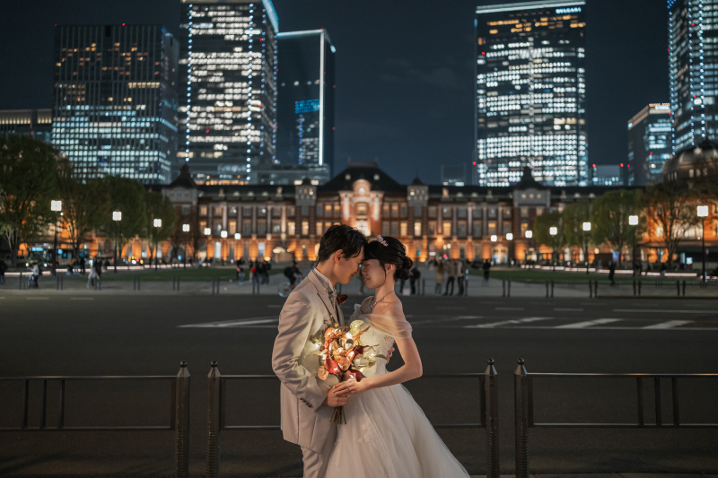 東京駅の夜景を背に向き合う二人