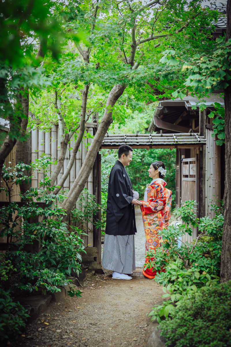 庭園の小径で前後に立つ新郎新婦様