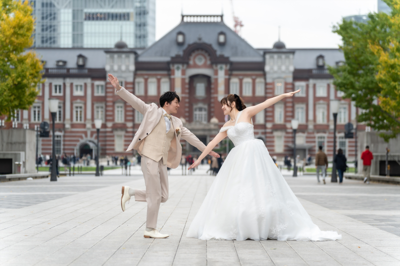 東京駅前で両腕を大きく広げるふたり