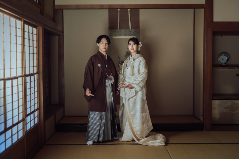 吊り照明の下で並んで立つ着物と白無垢
